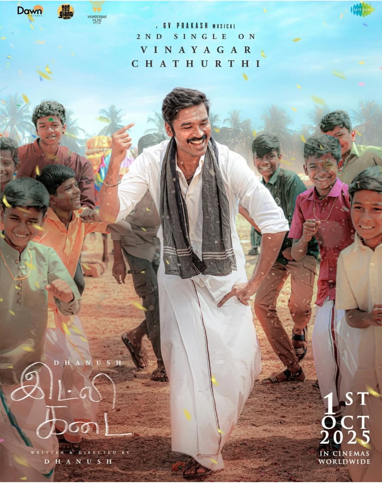“Dhanush dancing with children in a village celebration scene from Idly Kadai movie”