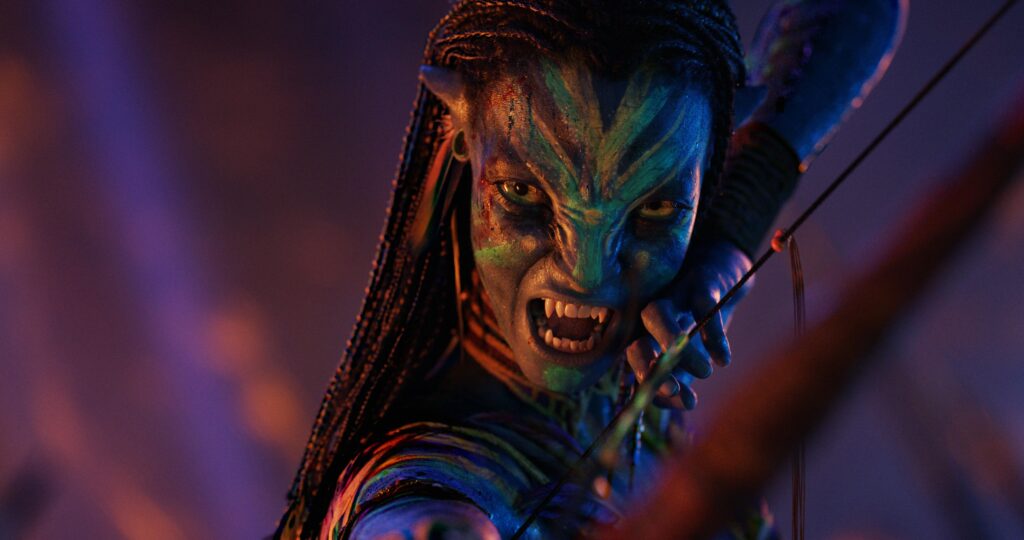 Ek fierce Na’vi warrior bow ko aim karte hue action scene me dikh raha hai – scene from Avatar: Fire and Ash.